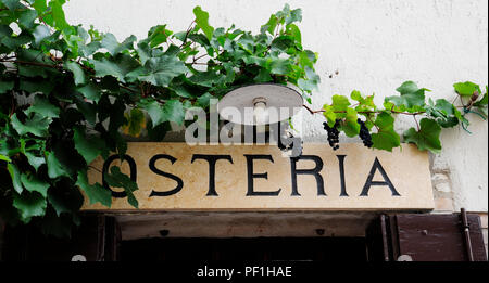 Osteria, taverne. Restaurant italien typique signe avec l'outillage et de vigne grappes de raisin. Arquà Petrarca, Veneto, Italie Banque D'Images