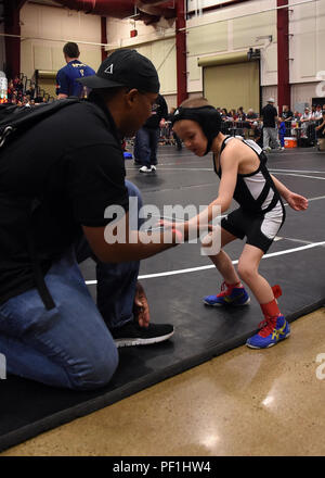 Morris Thomas, les enfants de la vaillance de l'entraîneur de l'équipe de catch, Ian Greer donne un bas-cinq avant son premier match à la compétition de lutte de l'état à Castle Rock, Colorado, le 28 février 2016. Les enfants de la vaillance a seulement été une équipe pour 11 mois, mais la cinquième place sur 191 équipes pendant le tournoi. (U.S. Air Force photo/Le s.. Debbie Lockhart) Banque D'Images