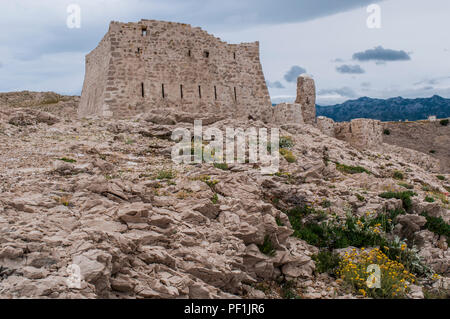 Croatie : temps orageux et vue sur la tour de guet en ruine en face de Paški Most, le pont 1968 qui relie la terre ferme et l'île de Pag Banque D'Images