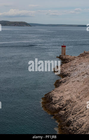 Croatie : temps orageux et le petit phare rouge sur la falaise en face de la plus Paški, 1968 pont qui relie la terre ferme et l'île de Pag Banque D'Images