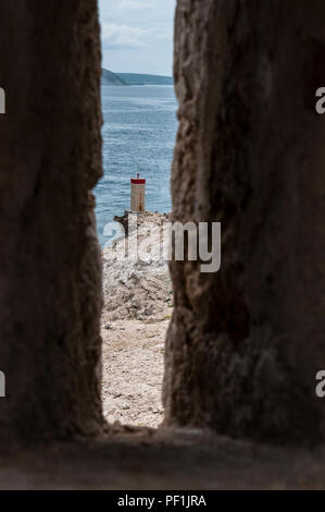 Croatie : temps orageux et le petit phare rouge sur la falaise en face de la plus Paški, 1968 pont qui relie la terre ferme et l'île de Pag Banque D'Images