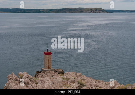 Croatie : temps orageux et le petit phare rouge sur la falaise en face de la plus Paški, 1968 pont qui relie la terre ferme et l'île de Pag Banque D'Images