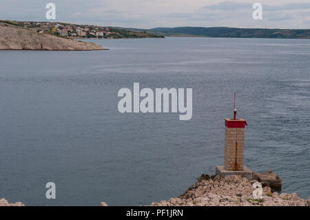 Croatie : temps orageux et le petit phare rouge sur la falaise en face de la plus Paški, 1968 pont qui relie la terre ferme et l'île de Pag Banque D'Images