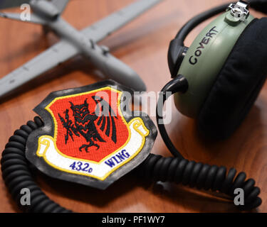 Aviateurs de la 432e Escadre/432e Escadre expéditionnaire à Creech Air Force Base, Nevada, participer à la journée d'orientation de Le Club Garçons et Filles 7 janvier 2016, à Las Vegas. Le patch de l'aile de gauche affiche un hibou tenant deux éclairs, et symbolise la capacité d'attaque globale. Le casque sur la droite est une pièce d'équipement utilisé par les pilotes et les exploitants de capteur d'avions téléguidés. Dans l'arrière-plan est un petit modèle MQ-9 Reaper, un aéronef à l'essai à Creech. (U.S. Air Force photo par un membre de la 1re classe Kristan Campbell/relâché). Banque D'Images