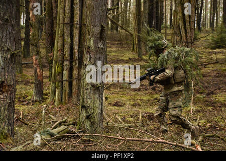 Un soldat affecté à Palehorse Troop, 4e Escadron, 2e régiment de cavalerie, se produit par le biais d'un espace boisé en direction de son feu l'objectif de l'équipe au cours de l'exercice de tir réel à la zone d'entraînement Grafenwoehr, situé près de la Caserne de Rose, de l'Allemagne, le 24 février 2016. L'appareil utilisé cet exercice de mise à jour et la formation de leurs soldats en combat au sol tactique techniques tout en également des gammes de tir réel sur leur FGM-148 Javelin des missiles et leur système de canon mobile Stryker. (U.S. Photo de l'armée par le Sgt. William A. Tanner) Banque D'Images