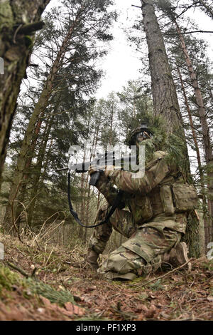 Le Cpl. Andrew Hernandez, un scout de cavalerie affecté à Palehorse Troop, 4e Escadron, 2e régiment de cavalerie, assure la sécurité de son équipe d'incendie de l'unité pendant son exercice de tir réel à la zone d'entraînement Grafenwoehr, situé près de la Caserne de Rose, de l'Allemagne, le 24 février 2016. L'appareil utilisé cet exercice de mise à jour et la formation de leurs soldats en combat au sol tactique techniques tout en également des gammes de tir réel sur leur FGM-148 Javelin des missiles et leur système de canon mobile Stryker. (U.S. Photo de l'armée par le Sgt. William A. Tanner) Banque D'Images