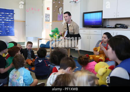 Le Lieutenant Matthew Jurcak, un dentiste avec le 1er Bataillon dentaire, 1er Groupe logistique maritime, un enfant permet de porter son manteau de dentiste au San Onofre Centre pour le développement de l'enfant lors d'un programme de sensibilisation de la santé dentaire à bord de Camp Pendleton, en Californie, le 23 février 2016. Bn dentaire. a été aux écoles et centres de développement de l'enfant autour de Camp Pendleton durant le mois de février pour le mois de la santé dentaire des enfants d'enseigner de bonnes habitudes d'hygiène buccale et de promouvoir la santé dentaire. (U.S. Marine Corps photo par le Cpl. Carson Gramley/libérés) Banque D'Images