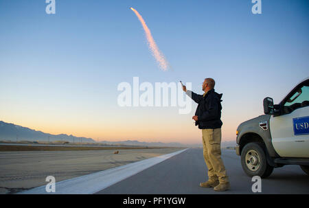 Biologiste de la faune Scott Stopak, du Département américain de l'Agriculture-Wildlife les incendies, des services d'un screamer pyrotechnique sur la ligne de vol à l'air de Bagram, en Afghanistan, le 24 février 2016. Stopak est avec le 455 e Escadre expéditionnaire de la Bureau de sécurité et travaille jour et nuit pour s'assurer que les animaux de différents types n'entravent pas les opérations de vol à l'aérodrome. (U.S. Air Force photo : Capt Bryan Bouchard) Banque D'Images