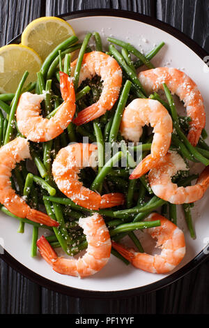 Faire revenir les crevettes avec des haricots verts, du fromage et de citron sur une assiette sur la table. Haut Vertical Vue de dessus Banque D'Images