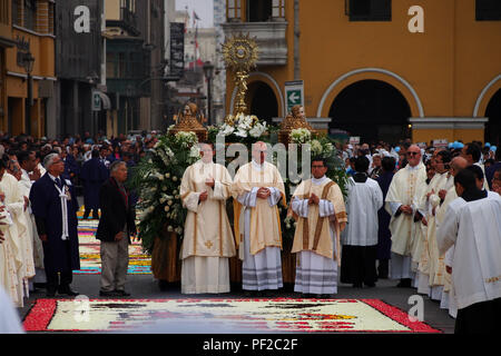 Prêtres marche sur des tapis de fleurs pendant la procession du Corpus Christi à Lima Banque D'Images