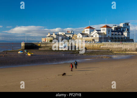 Les promeneurs de chiens sur une plage presque déserte en face de Knightstone Island en hiver à Weston-super-Mare, North Somerset, England, UK Banque D'Images