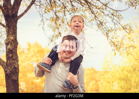 Père de donner son fils piggyback ride in autumn park, Adelaide Hills, Australie du Sud Banque D'Images