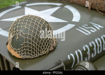 Image isolée d'un casque de la Seconde Guerre mondiale de l'armée américaine vu sur le capot d'une jeep de la Seconde Guerre mondiale restaurée. Les détails de l'étoile blanche et du numéro de série du véhicule sont visibles. Banque D'Images