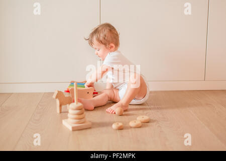 Cute little baby boy stacking rings dans la chambre Banque D'Images