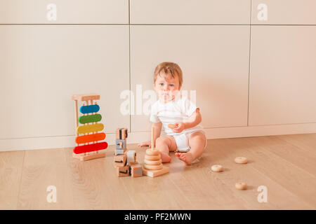 Cute little baby boy stacking rings dans la chambre Banque D'Images