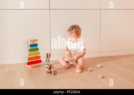 Cute little baby boy stacking rings dans la chambre Banque D'Images