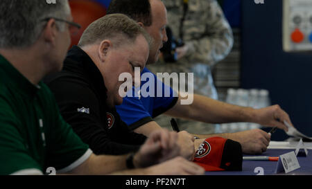 Chip Kelly, San Francisco 49ers entraîneur-chef, signe un cap sports au cours de la tournée 2016 Les entraîneurs, le 18 février 2016, à la base aérienne d'Aviano, en Italie. Les entraîneurs de l'équipe a rencontré des membres de l'Aviano pour répondre aux questions et accueillir une maquette moissonneuse-batteuse de football. (U.S. Air Force photo par un membre de la 1re classe Cary Smith/libérés) Banque D'Images