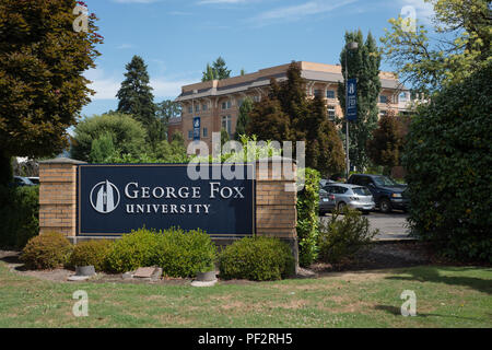 NEWBERG, Oregon le 15 août 2017, un panneau à l'entrée de George Fox University, avec un bâtiment en brique à l'arrière-plan. Banque D'Images