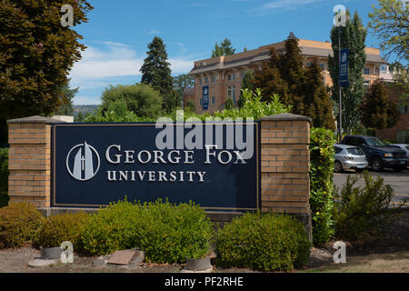 NEWBERG, Oregon le 15 août 2017, près d'un signe à un intrance pour George Fox University, avec un bâtiment en brique à l'arrière-plan. Banque D'Images