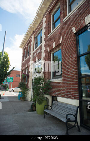 NEWBERG, Oregon le 15 août 2017, l'Hôtel de Ville de Newberg, un bâtiment en brique, au centre-ville avec un banc et deux faits à partir de tonneaux de vin. Banque D'Images