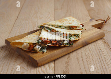 Les tortillas farcies de viande, légumes et fromage sur la plaque en bois Banque D'Images