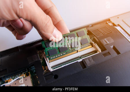 Installation technicien stick mémoire RAM (random access memory) à la douille sur l'ordinateur portable Banque D'Images