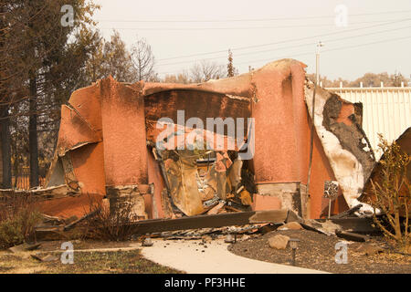 Accueil gravement brûlé avec des murs en stuc et accroché dans la récente tempête de feu feu sauvage à Redding en Californie. La fumée et des cendres dans l'air que la Banque D'Images