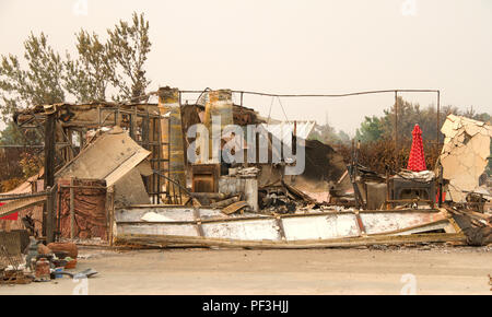 Accueil brûlé à la terre, porte de garage bouclée et la pose en tas après la récente tempête de feu feu sauvage à Redding, CA. La fumée et des cendres dans l'air comme Banque D'Images