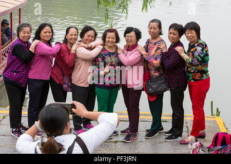 Yangzhou, Jiangsu, Chine. Les femmes posant pour une photo de groupe, mince West Lake Park. Banque D'Images