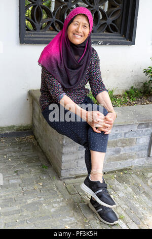 Yangzhou, Jiangsu, Chine. Femme ouïgoure au cimetière de Puhaddin, 13ème siècle missionnaire musulman. Banque D'Images