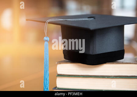 Close-up black cap a obtenu son diplôme et blue tassel mis sur le livre. Banque D'Images