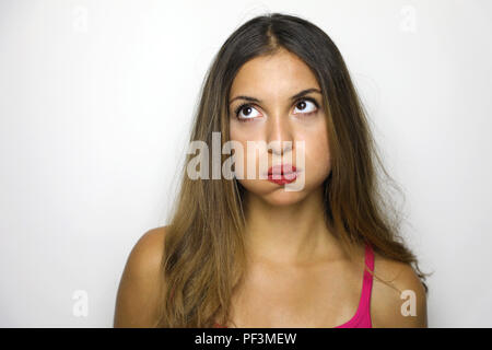 Portrait of young woman blowing mécontent de ses joues d'être bouleversé, démontrant son mécontentement. Belle fille avec expression boudeur sur isolé wh Banque D'Images