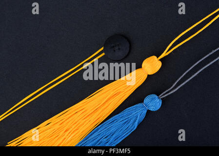 Close-up Graduation Cap noir et jaune, bleu tassel Banque D'Images