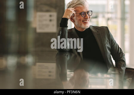 Senior business man relaxing at cafe. Young man sitting at coffee shop comptoir et à la voiture en souriant. Banque D'Images