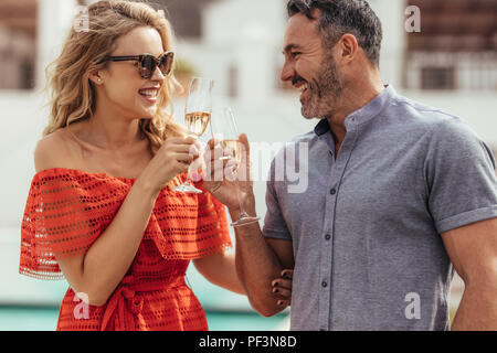 Magnifique portrait de couple toasting with wine et souriant. Bel homme et femme séduisante clinking wine à l'extérieur. Banque D'Images