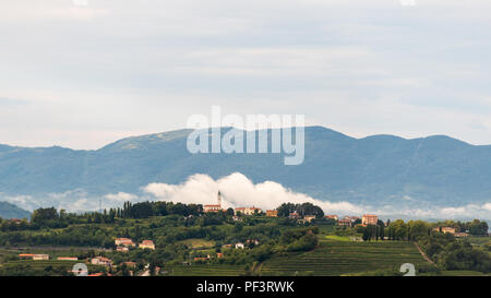 Village d'Steverjan, San Floriano del Collio, Italie avec en face de l'église basse blanc nuage blanc, Goriska Brda, de vignobles et de vergers Banque D'Images