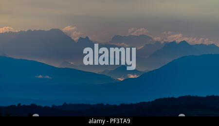 Dolomites le matin avec les nuages au-dessus, les rayons du soleil illuminent le plus éloigné des pics de montagne Banque D'Images