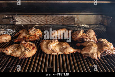 Poulets griller sur un gril à gaz Banque D'Images