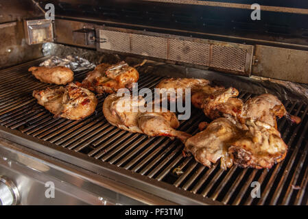 Poulets griller sur un gril à gaz Banque D'Images