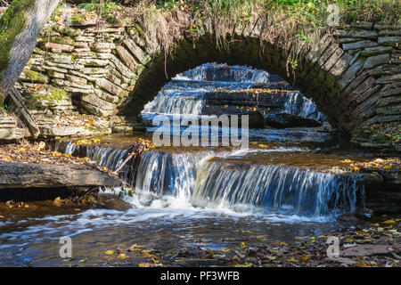 Vieux pont voûté avec cascade Banque D'Images