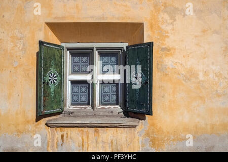 Mur et fenêtre d'une belle maison de brique peints et décorés à Zuoz (Grisons, Suisse) en mode 'typique' Engadiner. Banque D'Images