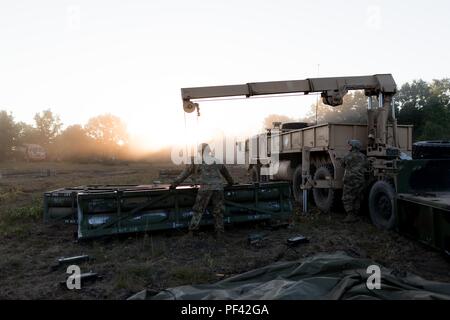 La CPS. Cody Jensen, camionneur, 147e de l'avant Support Compagnie, 1er Bataillon, 147e Régiment d'artillerie, Roslyn, S.D., guides une balise d'un tube de missiles Système de lance-roquettes multiple sur un chariot vide sous la forme d'un lit. Steven Smith, camionneur, 147e FSC, exploite le système de treuil sur 10 Août, 2018. Le Dakota du Sud les soldats de la Garde nationale d'Armée participent à Northern Strike, une multinationale interarmées exercice de tir réel interarmes au Camp Grayling, au Michigan (É.-U. Photo de la Garde nationale par la CPS. Joshua Boisvert) Banque D'Images