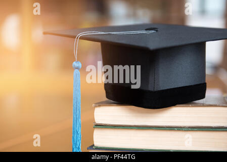 Close-up black cap a obtenu son diplôme et blue tassel mis sur le livre. Banque D'Images