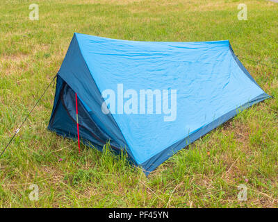 Tourist tente d couleur bleue sur l'herbe verte. Banque D'Images