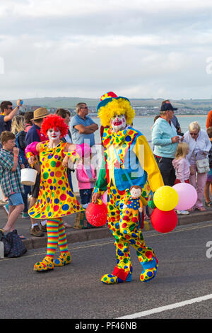 Clowns colorés qui prennent part à la procession annuelle carnival parade à Weymouth, Dorset UK en Août Banque D'Images