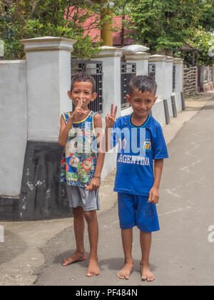 Ambon en Indonésie - 11 Février 2018 : deux garçons indonésien dans des vêtements colorés sur la rue dans le petit village de l'île d'Ambon, Moluques, Maluki Banque D'Images