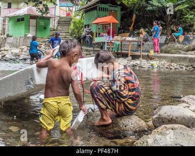 L'île d'Ambon, Indonésie - 11 Février 2018 : deux garçons indonésien jouant dans la rivière sur l'île d'Ambon, Moluques, Maluki Banque D'Images