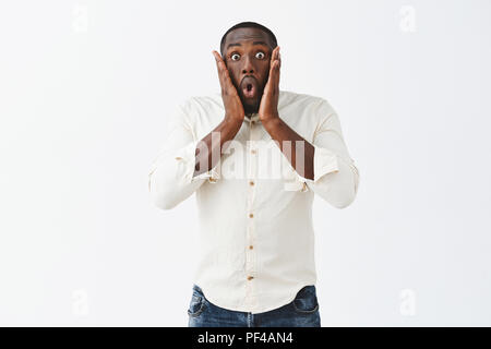 Révélation choquante été faite, ne peut tenir l'étonnement à l'intérieur. Stupéfait et impressionné sans voix African American businessman en chemise, le pliage des lèvres, holding palms près de bouche ouverte, stare Banque D'Images