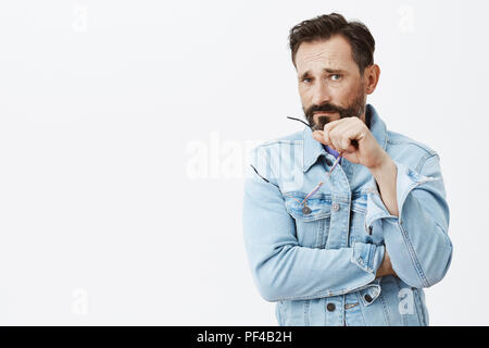 Décision insatisfaite a fait le pauvre, malheureux. Portrait de déplut sombre père adultes avec barbe et moustache en Viper, décollant de verres et de froncer tout en étant triste sur fond gris Banque D'Images