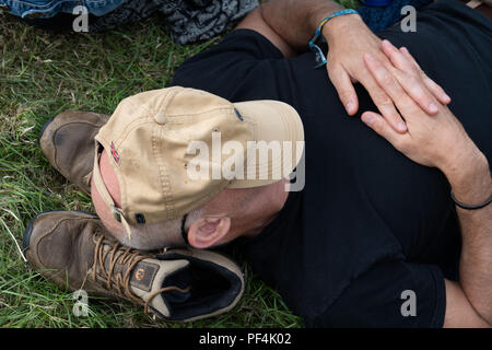 Glanusk Park, Brecon, pays de Galles, 18 août 2018. Deuxième jour du festival de musique Green Man dans les montagnes Brecon Beacons au pays de Galles. Un homme avec sa casquette sur les yeux. Les fans fatigués dorment et somnolent par un après-midi chaud à travers la foule et le site pendant le festival. Crédit : Rob Watkins/Alamy Live News Banque D'Images